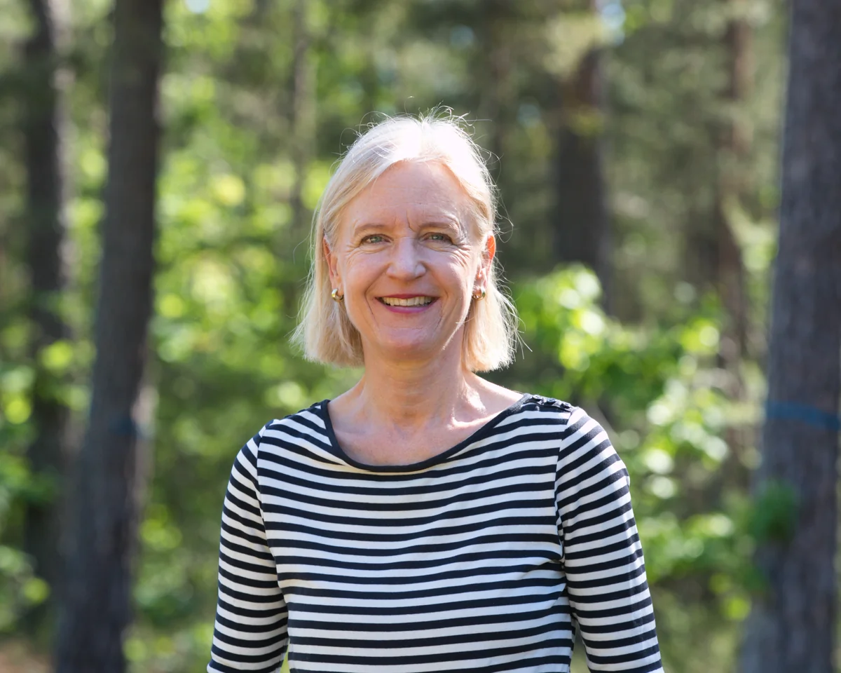 Britta Ernst, Heilerin im Raum Erlangen, lächelnd in einem lichten Wald
